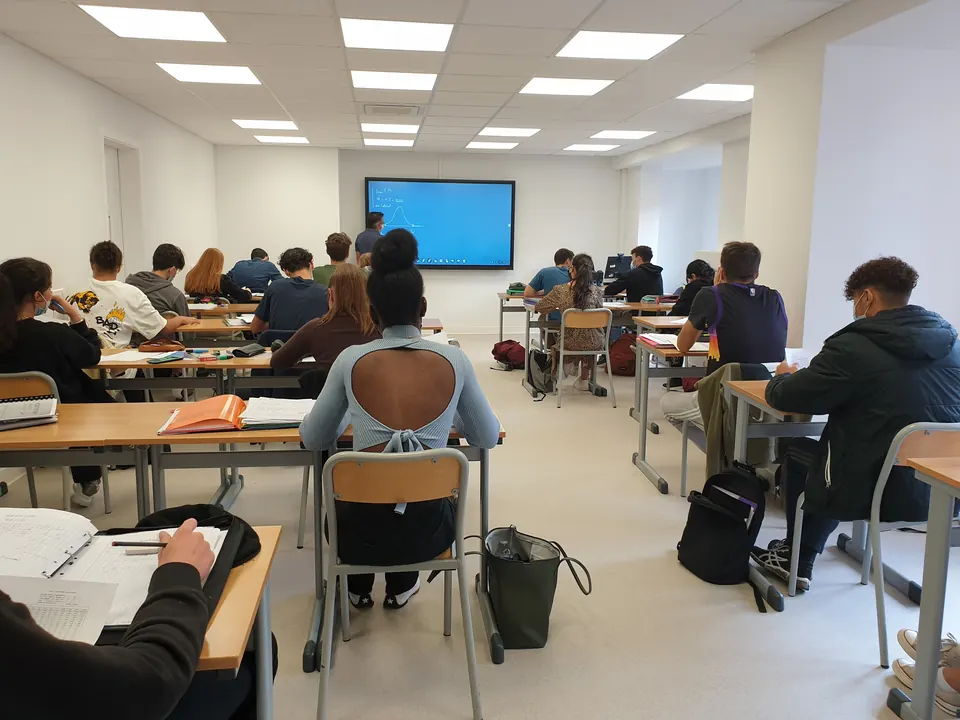 Apprenants travaillant sur leurs documents pendant un cours dans une salle d'Exactétudes